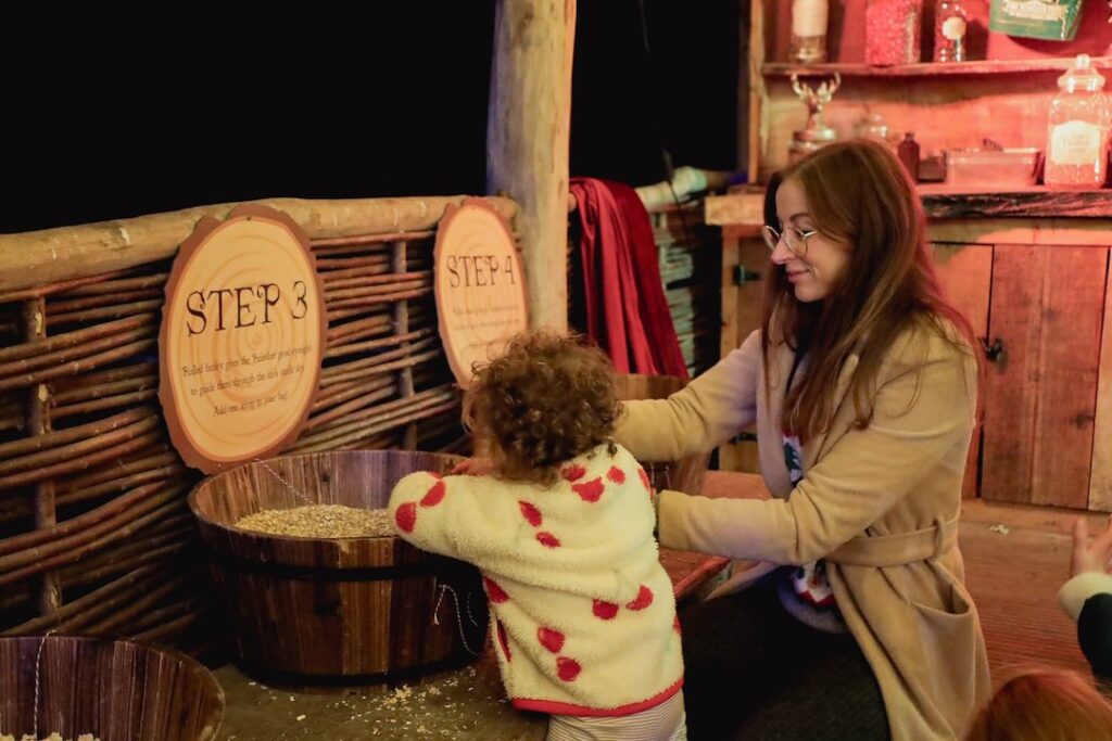 Child and mother making reindeer food in wooden lodge.