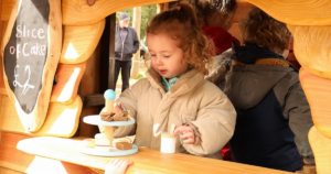 child playing in a wooden role-play house
