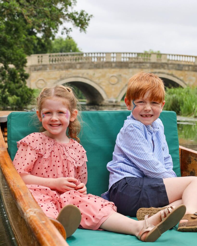 Two children enjoying a punt boat ride with face painting at Audley End Enchanted Railway during the Summer Festival.